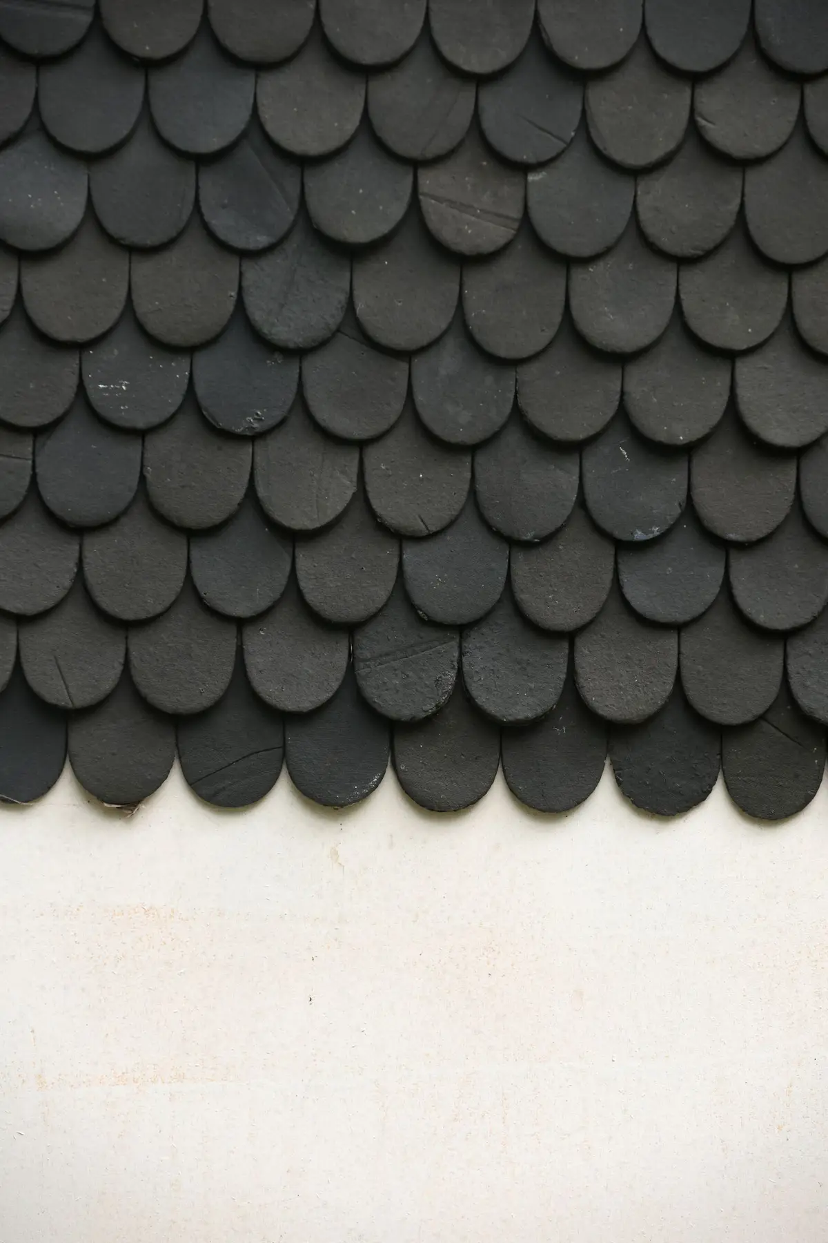 Close-up of black textured asphalt roof shingles.
